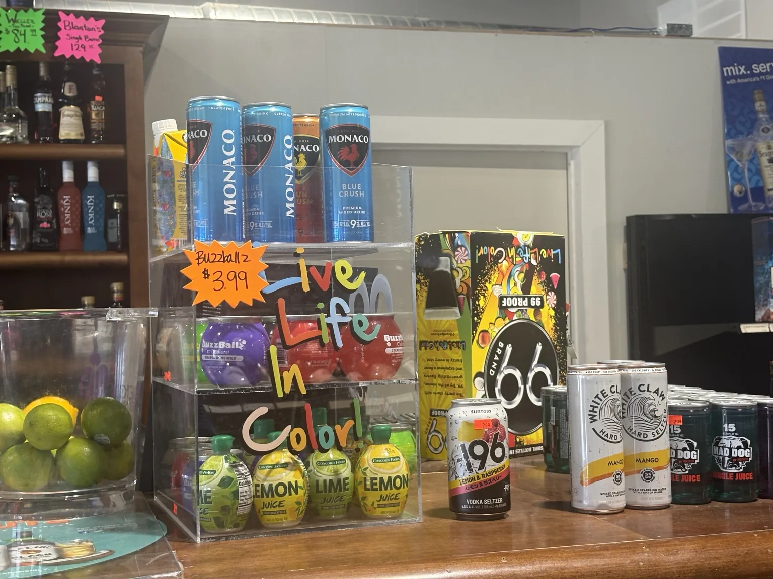 Monaco canned cocktails, BuzzBallz, White Claw hard seltzer and lemon and lime juice displayed at the counter