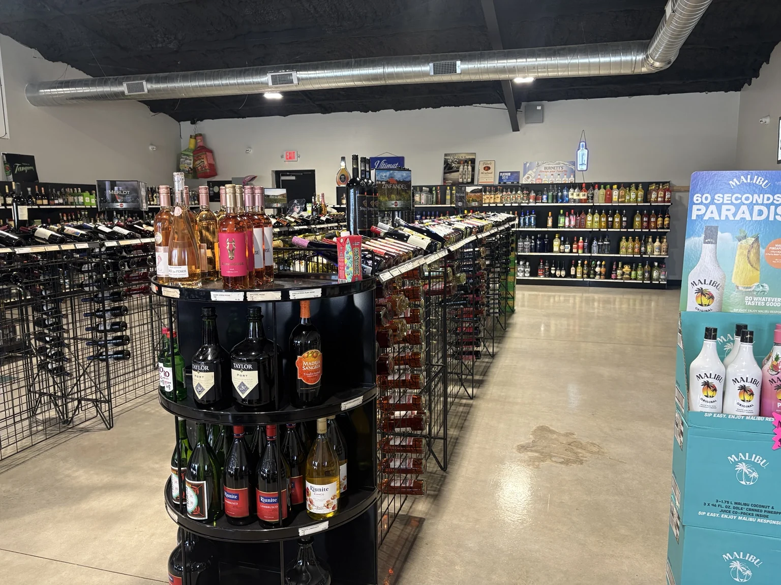 A wide view inside One Stop Liquor, with wine displays and stocked shelves