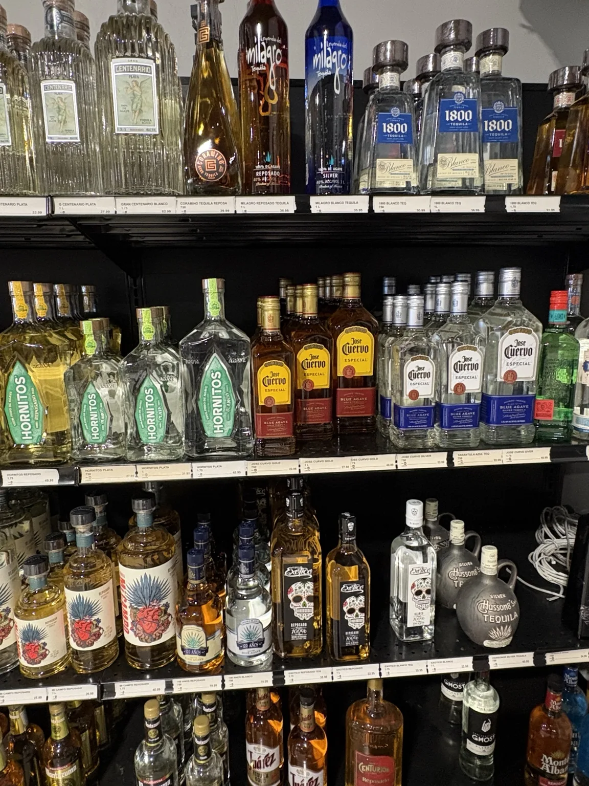 1800 and José Cuervo tequila above Lunazul and mezcal bottles at One Stop Liquor in Bethany, Oklahoma