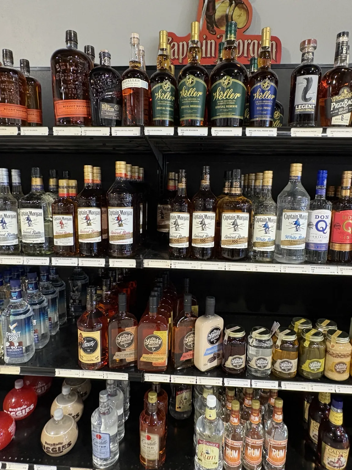 Bourbon bottles above Captain Morgan spiced rum, cream liqueurs and bottled drinks at One Stop Liquor in Bethany, Oklahoma