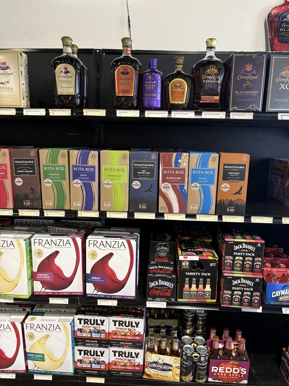 Crown Royal bottles above Bota Box and Franzia boxed wines, hard seltzer and canned drinks at One Stop Liquor in Bethany, Oklahoma