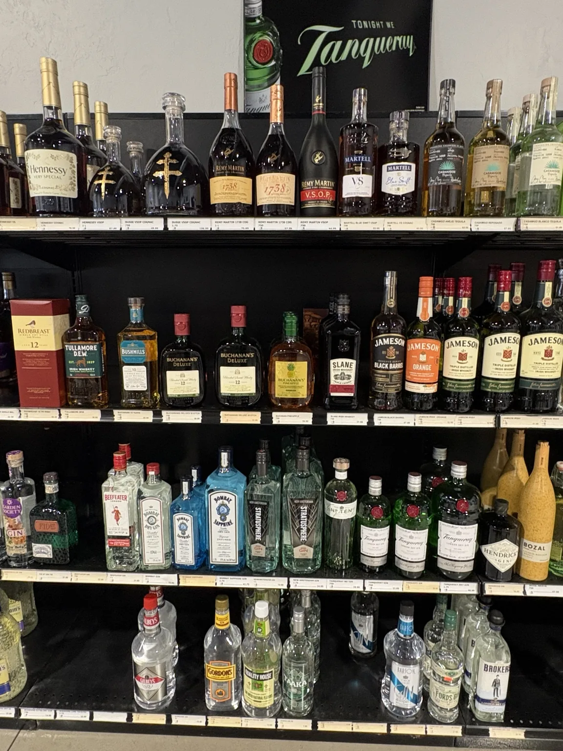 Hennessy and Rémy Martin cognac above Jameson, Bushmills, Bombay Sapphire and Tanqueray bottles at One Stop Liquor in Bethany, Oklahoma