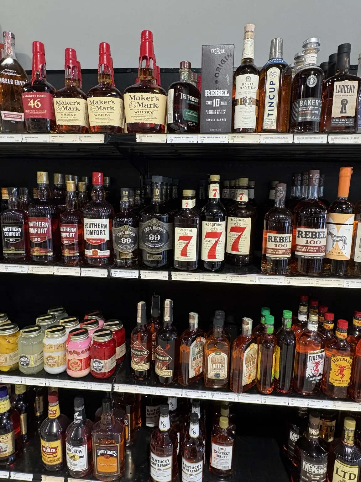 Maker’s Mark bourbon above American whiskey bottles and canned cocktails at One Stop Liquor in Bethany, Oklahoma