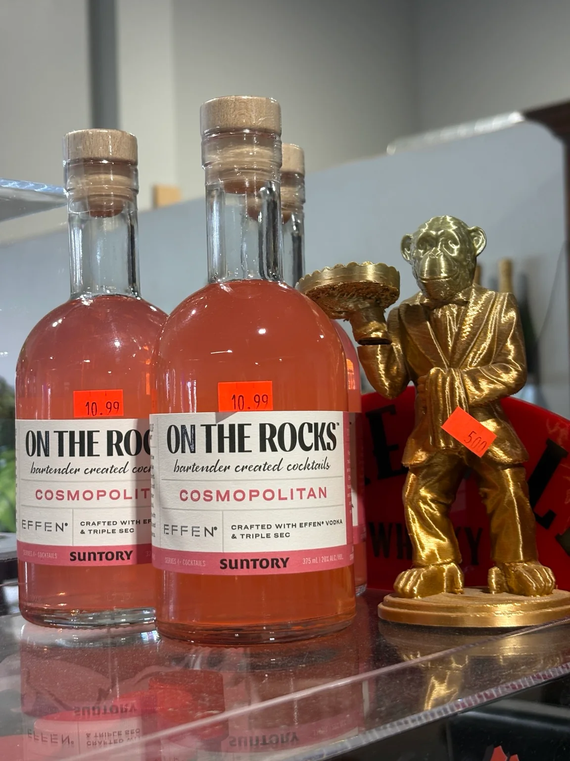 On The Rocks Cosmopolitan bottled cocktails beside a gold monkey display at One Stop Liquor in Bethany, Oklahoma