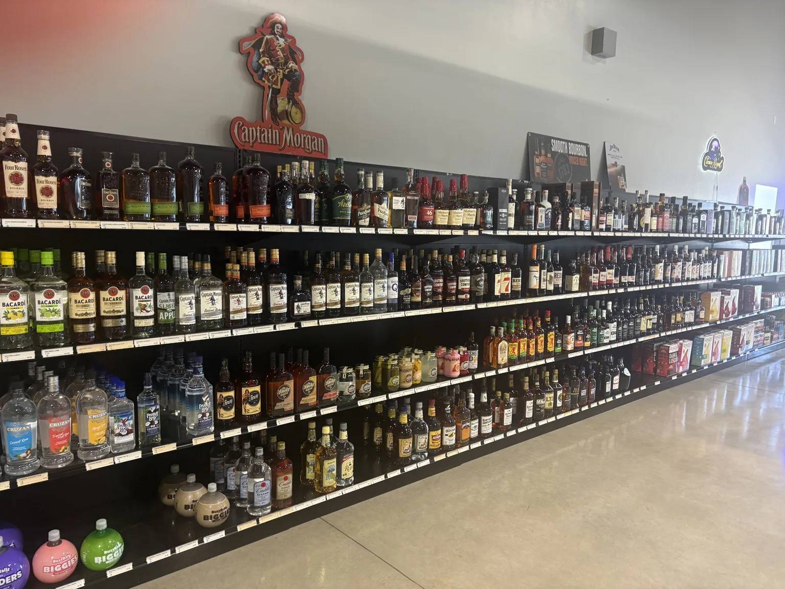 A wide view of the rum and whiskey shelves inside One Stop Liquor’s new location