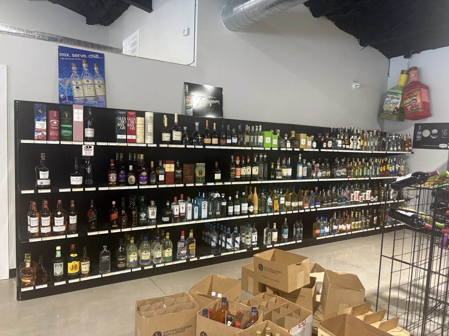 Scotch, Irish whiskey and gin shelves with Glenmorangie, Jameson, Johnnie Walker and Hendrick’s