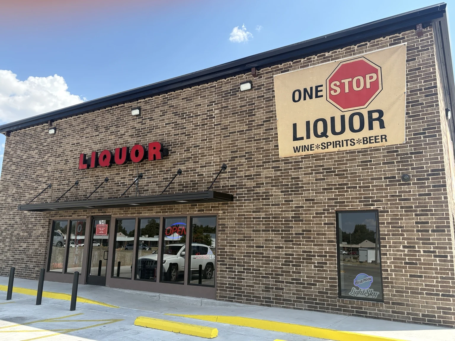 The brick storefront and One Stop Liquor sign at the new location