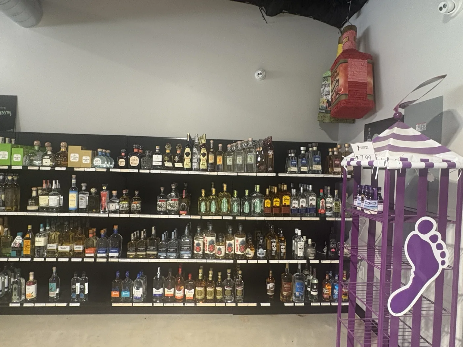 Tequila shelves featuring Patrón, Don Julio, Espolòn, 1800 and other bottles